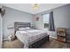 Cozy bedroom with a rustic wood bedframe, floral bedding, and a bright window for a tranquil, inviting retreat at 317 Bonanza Dr, Erie, CO 80516