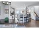 Bright dining area showing bar seating and an open floor plan with access to the kitchen and entry at 317 Bonanza Dr, Erie, CO 80516