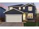 Charming two-story home with a white garage door and a beautifully maintained front yard at 317 Bonanza Dr, Erie, CO 80516