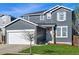 Attractive two-story house featuring a well-manicured lawn and an attached white two car garage at 317 Bonanza Dr, Erie, CO 80516