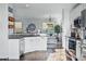 Bright kitchen featuring white cabinets, sleek countertops, stainless steel appliances, and an adjacent dining area at 317 Bonanza Dr, Erie, CO 80516