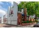 Rear exterior view highlighting garages and brick accents, shaded by mature trees at 1030 Jersey St # 1, Denver, CO 80220