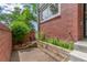 Cozy patio area showcasing brick accents and a small garden area with trees at 1030 Jersey St # 1, Denver, CO 80220
