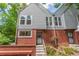 Cozy townhome featuring brick accents and a tidy front garden area with shade trees at 1030 Jersey St # 1, Denver, CO 80220