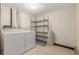 Functional laundry area with white appliances and metal shelving for organized storage at 1030 Jersey St # 1, Denver, CO 80220
