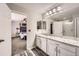Bathroom featuring white cabinetry, a granite countertop, and views to the main bedroom at 77 N Jackson Gap Way, Aurora, CO 80018