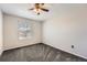 Empty bedroom featuring gray carpeting, a ceiling fan, and a large window with blinds at 77 N Jackson Gap Way, Aurora, CO 80018