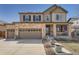 Charming two-story home with a stone facade, covered porch, well-manicured lawn, and a two-car garage at 77 N Jackson Gap Way, Aurora, CO 80018