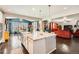 Spacious kitchen island with bar stool seating, a large farm sink, and open to the dining and living areas at 77 N Jackson Gap Way, Aurora, CO 80018