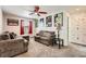 Inviting living room features a large sectional sofa and tasteful wall decor, lit by a modern ceiling fan at 77 N Jackson Gap Way, Aurora, CO 80018