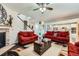 Spacious living room featuring a stone fireplace, ceiling fan and an open layout with hardwood floors at 77 N Jackson Gap Way, Aurora, CO 80018