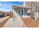 Inviting front porch with a striking blue door and freshly painted railings at 1267 Quitman St, Denver, CO 80204