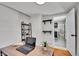 Bright home office featuring a wood desk, floating shelves, and doorway to the bathroom at 1267 Quitman St, Denver, CO 80204