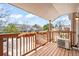 Cozy balcony with wooden railing, planters, and outdoor air conditioning unit overlooking the neighborhood street at 9677 W Chatfield Ave # E, Littleton, CO 80128