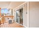Balcony with sliding glass door entry to the home with a mounted AC unit and wooden floors at 9677 W Chatfield Ave # E, Littleton, CO 80128