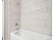 Updated bathroom with tiled shower and tub combination with stylish decorative tile accents at 9677 W Chatfield Ave # E, Littleton, CO 80128