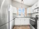 Modern kitchen with stainless steel appliances, white cabinets, and granite countertops at 9677 W Chatfield Ave # E, Littleton, CO 80128
