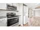 Kitchen with stainless steel appliances and granite countertops and in-unit laundry closet at 9677 W Chatfield Ave # E, Littleton, CO 80128