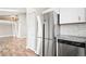 Kitchen with stainless steel refrigerator and granite countertops leading to the lofted bedroom at 9677 W Chatfield Ave # E, Littleton, CO 80128