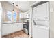 Bright kitchen featuring white cabinets, stainless steel appliances, and in-unit laundry closet at 9677 W Chatfield Ave # E, Littleton, CO 80128