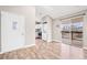 Open-concept living space with hardwood floors, laundry, kitchen access, and balcony sliding doors at 9677 W Chatfield Ave # E, Littleton, CO 80128