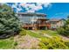 Rear exterior of the house displaying the two-level deck, hot tub, and landscaped backyard on a sunny day at 19105 Eagle Ridge Dr, Golden, CO 80401