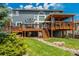 Backyard view showing a two-level deck with outdoor seating and a well-manicured lawn with rock drainage feature at 19105 Eagle Ridge Dr, Golden, CO 80401