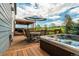 Backyard wood deck with hot tub, dining set with umbrella, and covered patio at 19105 Eagle Ridge Dr, Golden, CO 80401