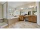 Bright bathroom with a large soaking tub, tiled floors, a double vanity, and a separate glass-enclosed shower at 19105 Eagle Ridge Dr, Golden, CO 80401