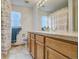 Bright bathroom with a double sink vanity, blue hand towels, and patterned shower curtain with natural light at 19105 Eagle Ridge Dr, Golden, CO 80401