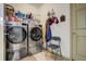 Laundry room with stainless steel washer and dryer, overhead shelving, and a neutral-colored door at 19105 Eagle Ridge Dr, Golden, CO 80401