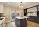 Modern kitchen boasts an island with a white countertop, contrasting cabinets, and stylish lighting fixtures at 345 S Ogden St, Denver, CO 80209