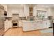 Stylish kitchen with stainless steel appliances, marble backsplash and island, and white cabinets at 345 S Ogden St, Denver, CO 80209