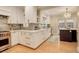 Modern kitchen with stainless steel appliances, marble backsplash and island, and white cabinets at 345 S Ogden St, Denver, CO 80209