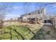 A spacious backyard with a well-maintained lawn, a wooden fence and a deck at 5559 S Quemoy Cir, Aurora, CO 80015