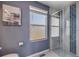 Modern bathroom features blue walls, window, glass shower and contemporary art at 5559 S Quemoy Cir, Aurora, CO 80015
