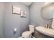 Stylish powder room with blue walls, vanity sink, round mirror and decorative art at 5559 S Quemoy Cir, Aurora, CO 80015