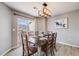 Cozy dining area with a rustic wooden table, modern light fixture, and natural light at 5559 S Quemoy Cir, Aurora, CO 80015