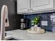 Close up of kitchen features coffee maker, beverage tray, white cabinets and blue subway tile backsplash at 5559 S Quemoy Cir, Aurora, CO 80015