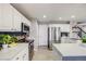 Modern kitchen with white cabinets, stainless steel appliances, and sleek countertops at 5559 S Quemoy Cir, Aurora, CO 80015