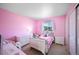 Bedroom with pink walls, white furniture, and a bright window at 1386 Avgare Way, Erie, CO 80516