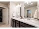 Bathroom with dual sinks, marble countertops, and a large mirror at 56 Magnolia Ct, Erie, CO 80516
