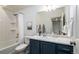 Stylish bathroom features tub with shower and blue vanity cabinet with modern fixtures and decor at 56 Magnolia Ct, Erie, CO 80516