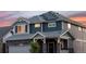Close-up of a two-story house featuring solar panels, a stone facade, and a well-maintained yard at 56 Magnolia Ct, Erie, CO 80516