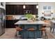 Modern kitchen with dark wood cabinets, stainless steel appliances, and a large center island with seating at 56 Magnolia Ct, Erie, CO 80516