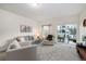 Cozy living room featuring plush gray seating and sliding glass doors to the outdoor patio area at 56 Magnolia Ct, Erie, CO 80516