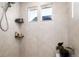 Modern shower with tiled walls, niche shelving, and dual windows for natural light at 56 Magnolia Ct, Erie, CO 80516