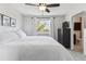 Cozy bedroom with a large bed, dark dresser, and a view into the bathroom at 5664 S Zang St, Littleton, CO 80127