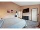 Well-lit bedroom with soft carpet, TV, neutral walls, and access to connected rooms at 3593 S Gibralter Cir, Aurora, CO 80013