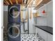 Laundry area with black and white star tile and new stacked appliances at 3593 S Gibralter Cir, Aurora, CO 80013